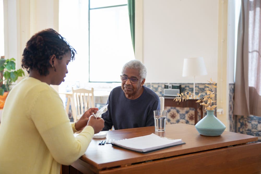 Carer discussing care plan with elderly client at home